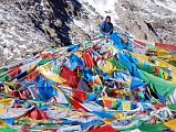 54 Tashi Connects Prayer Flags To Top Of Dolma Do Rock On Mount Kailash Outer Kora Only the shape of the large Dolma Do, Rock of Dolma (Tara), that Tibetans call Phawang Mebar is visible beneath all the prayer flags. My local guide Tashi connects his prayer flags to the rock.